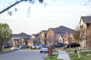 A street of well-maintained residential rental homes in a quiet neighborhood, representing compliant real estate investments.